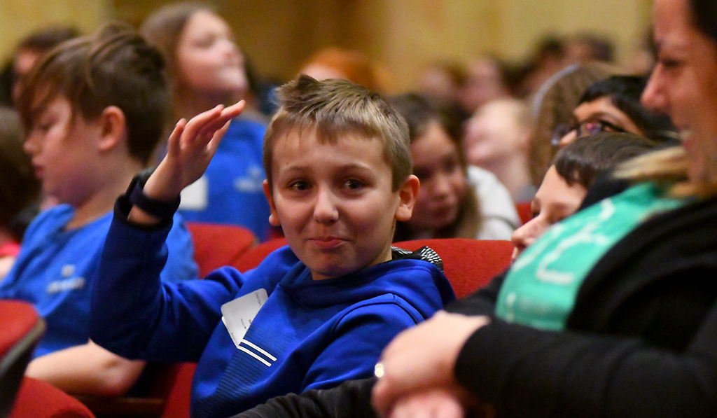 Logan Baker sits in the crowd with his teacher